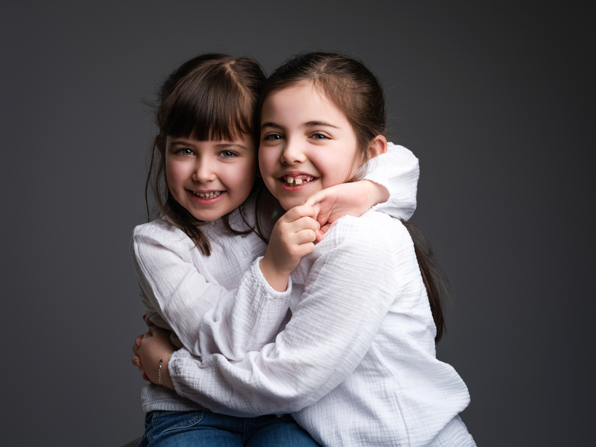 Portrait doux d'une fratrie se faisant un câlin, séance photo d'enfants en studio en Lozère