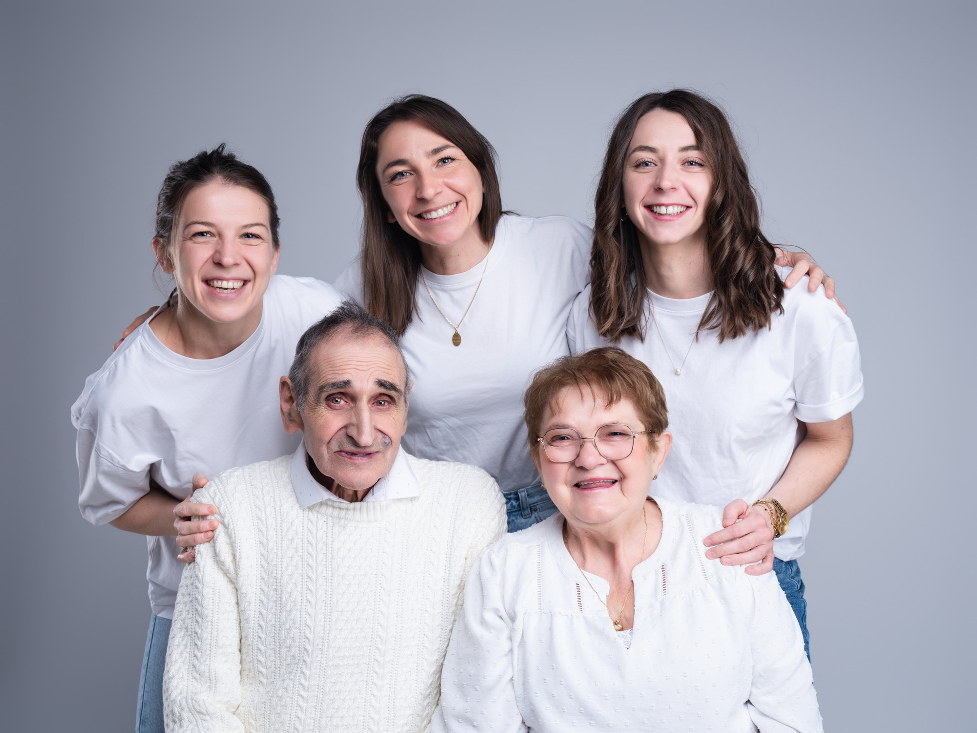 Moment de rire et de complicité en famille photographié sur un fond neutre à Mende