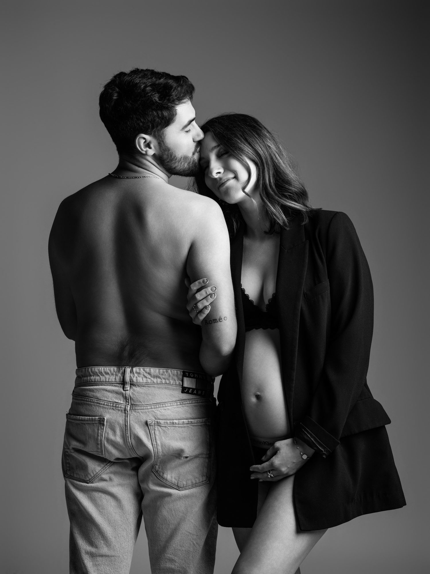 Séance photo de maternité en duo noir et blanc, le couple posant de manière élégante dans notre studio lozérien